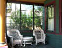 Picture of sunny Victorian porch with white wicker rockers