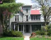 Picture of 96 Kenyon:  Grey-green toned Italianate with round wrap-around porch