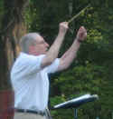 Conductor of the brass band - raising his baton.