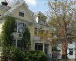 Greek Revival Victorian in pale yellow, white and forest green trim