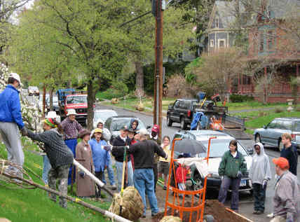 Jack Hale on Kenyon Street explaining how to plant the trees to twenty neighbors.  Equipment all around  